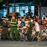 Policiais controlam a movimentação de uma multidão durante um evento noturno.