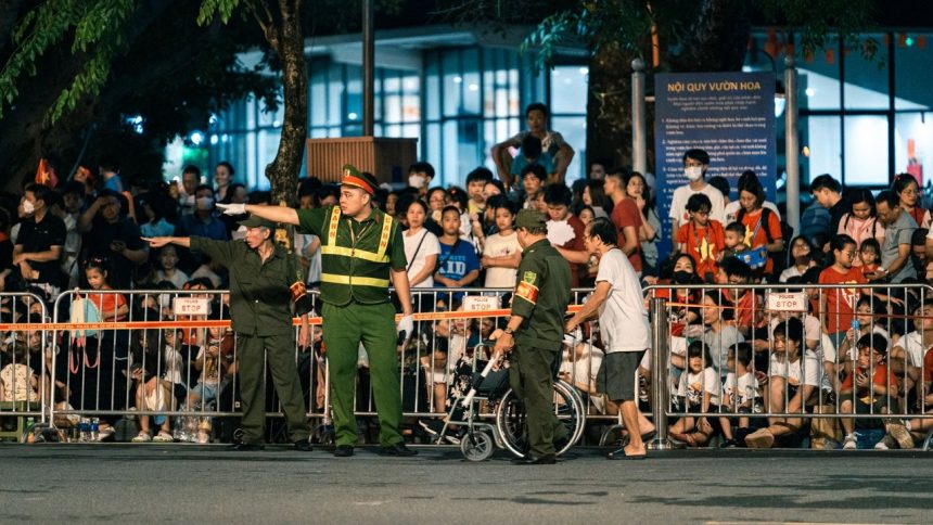 Policiais controlam a movimentação de uma multidão durante um evento noturno.
