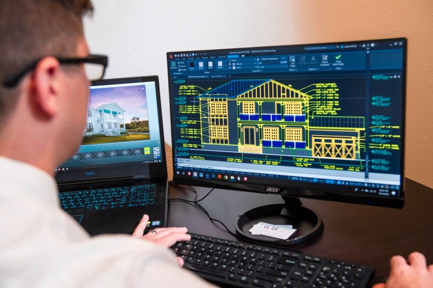 Arquiteto analisa projetos detalhados de uma residência exibidos em dois monitores, em um escritório moderno.